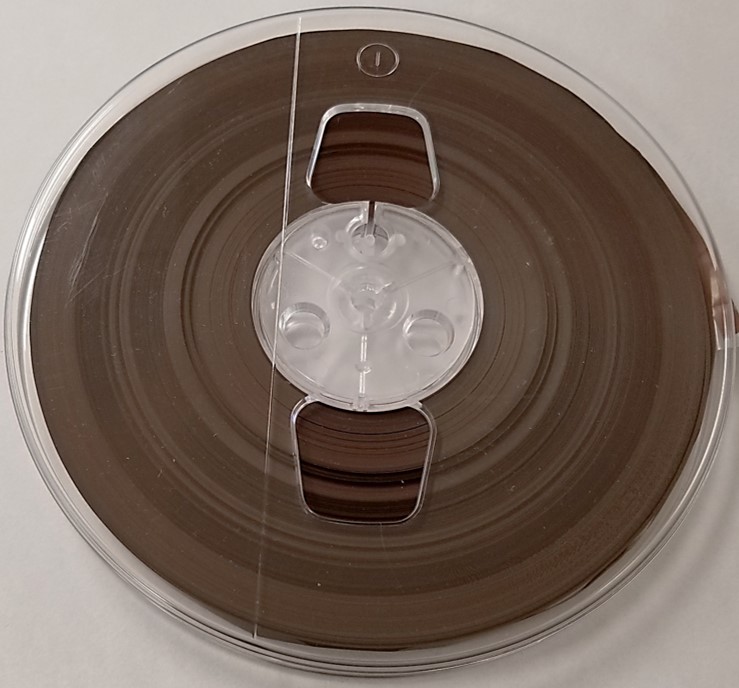 Audiotape reel with popped strands. Many layers of tape are protruding out of this poorly wound tape pack and are vulnerable to edge damage.